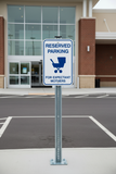 Reserved parking sign for expectant mothers in front of a building entrance.